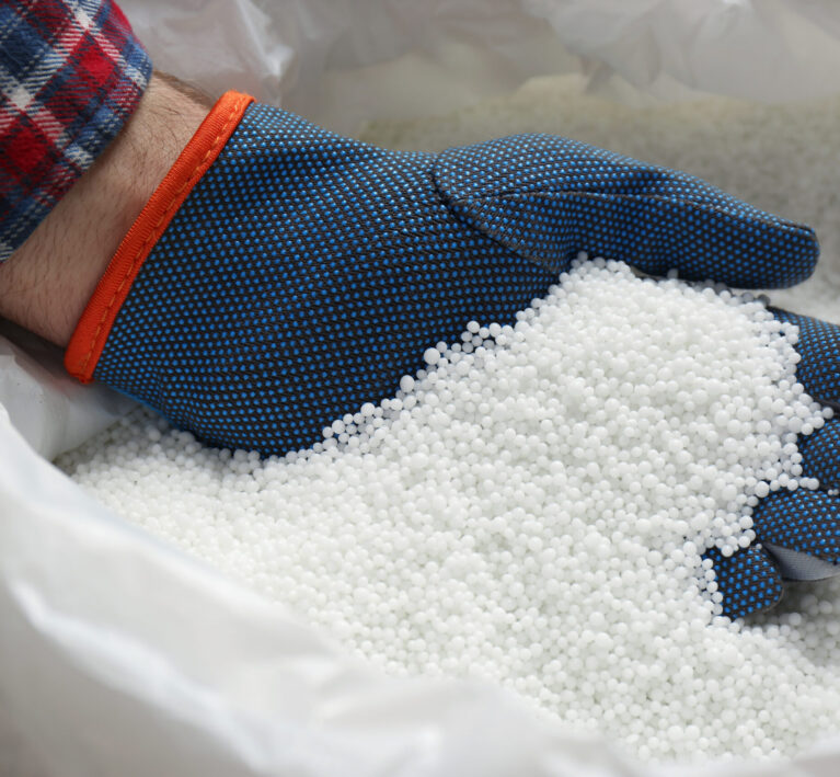 Farmer taking pellets of ammonium nitrate from bag, closeup. Mineral fertilizer
